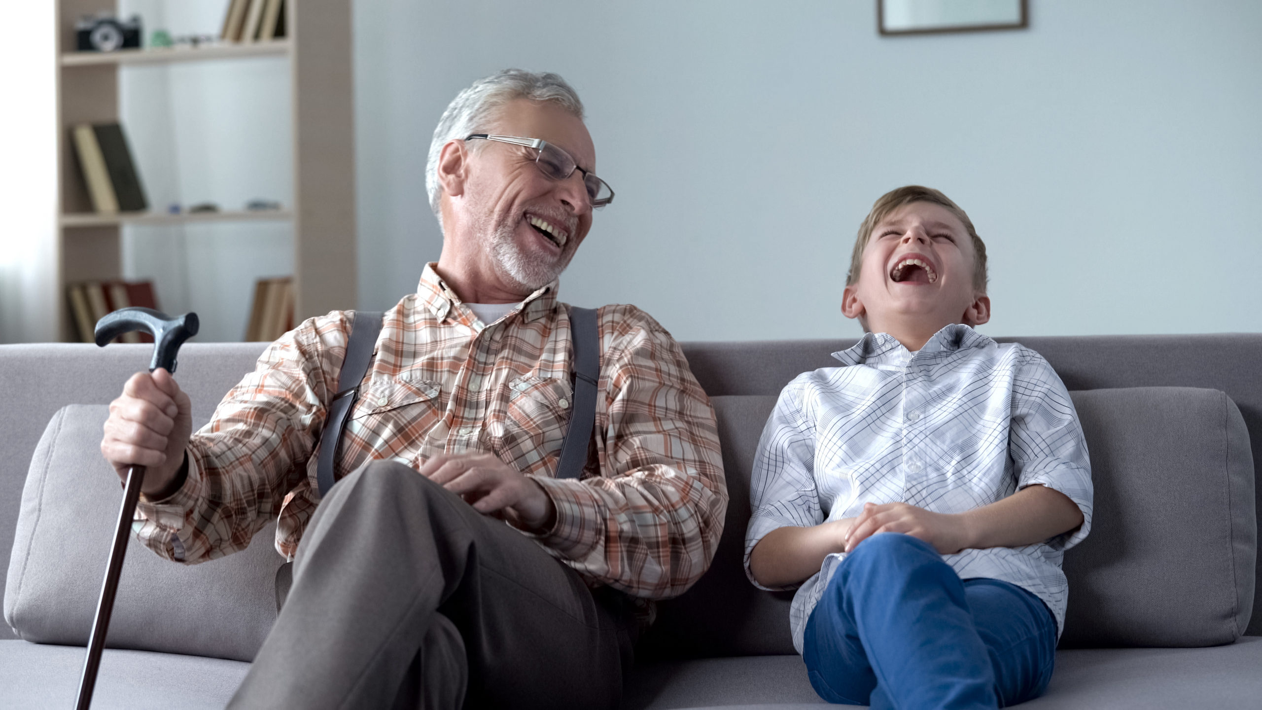 Old man and boy laughing genuinely, joking, valuable fun moments together